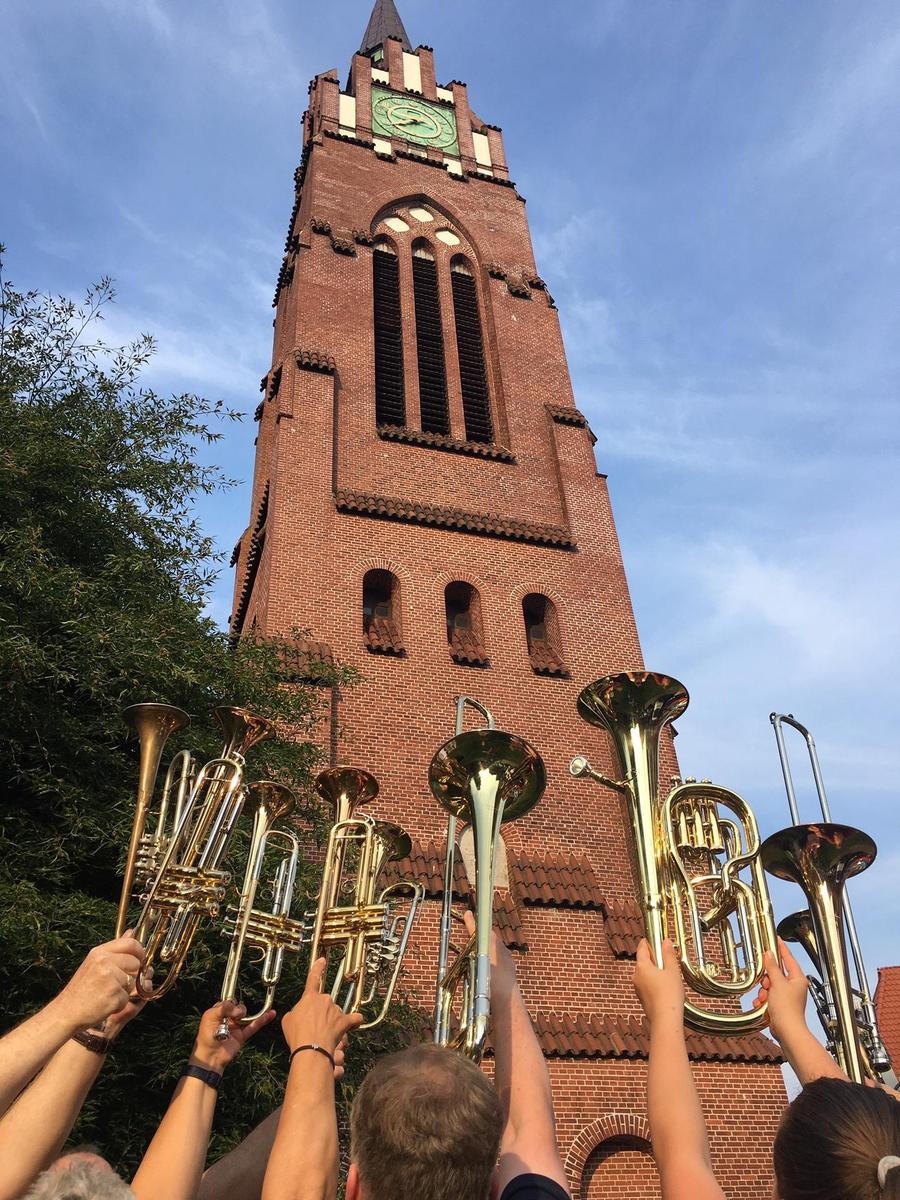 Bläser vor Kirchturm